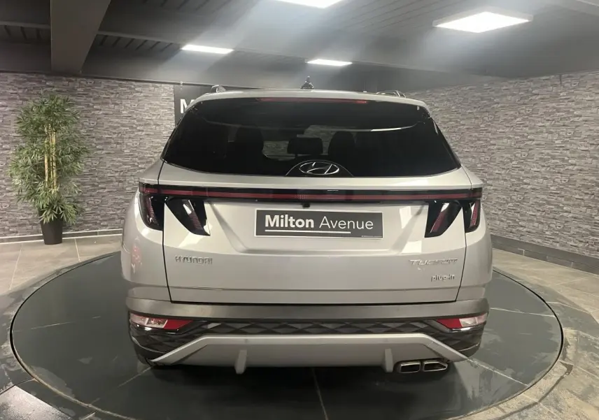 Vue arrière d'un Hyundai Tucson gris métallisé 2023 avec feux arrière LED et double sortie d'échappement.