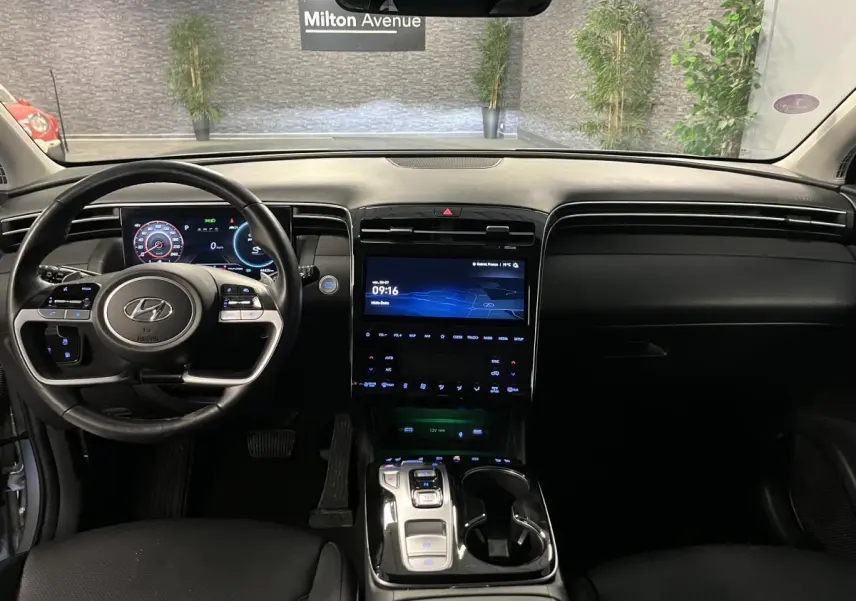 Intérieur noir du Hyundai Tucson 2023 vu de face, avec tableau de bord numérique et large écran tactile central.