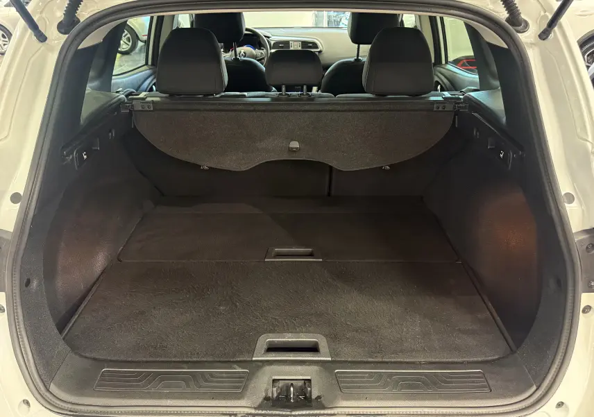 Coffre ouvert d'un Renault Kadjar blanc glacier 2020, vue arrière montrant l'espace de chargement et la banquette arrière.