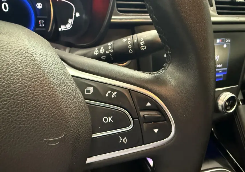 Gros plan sur le volant noir du Renault Kadjar 2020 avec commandes intégrées et tableau de bord digital bleu.