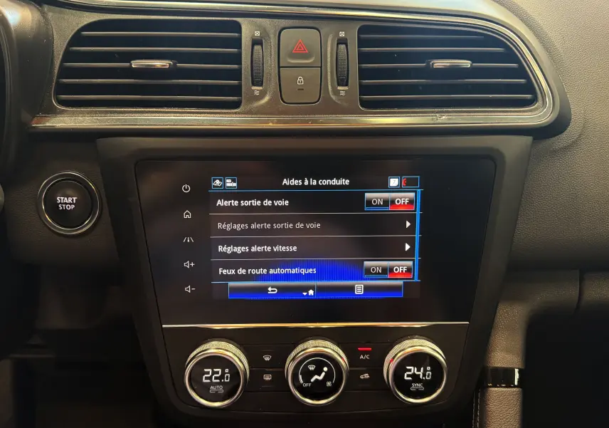 Tableau de bord du Renault Kadjar blanc, vue centrale sur l'écran tactile et commandes climatisation avec bouton Start/Stop.