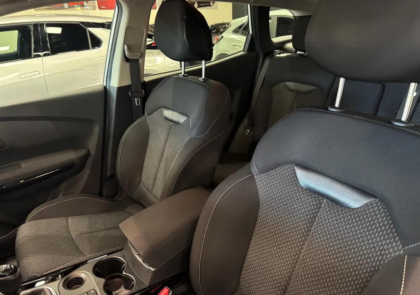 Vue intérieure du Renault Kadjar 2020 montrant les sièges avant en tissu noir et la console centrale avec accoudoir.