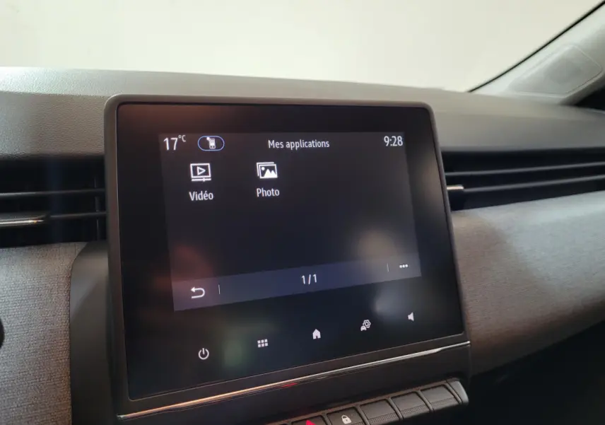Écran tactile central allumé montrant les applications vidéo et photo dans l’habitacle gris clair d’une Renault Clio 2025.