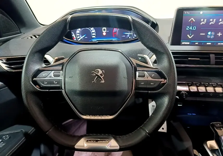 Vue intérieure centrée sur le volant cuir multifonctions du Peugeot 3008 GT Line avec tableau de bord digital.