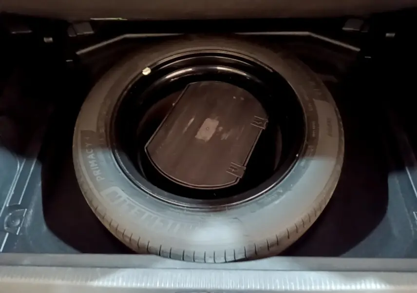 Vue rapprochée de la roue de secours noire dans le coffre du Peugeot 3008 gris foncé, version GT Line 2020.