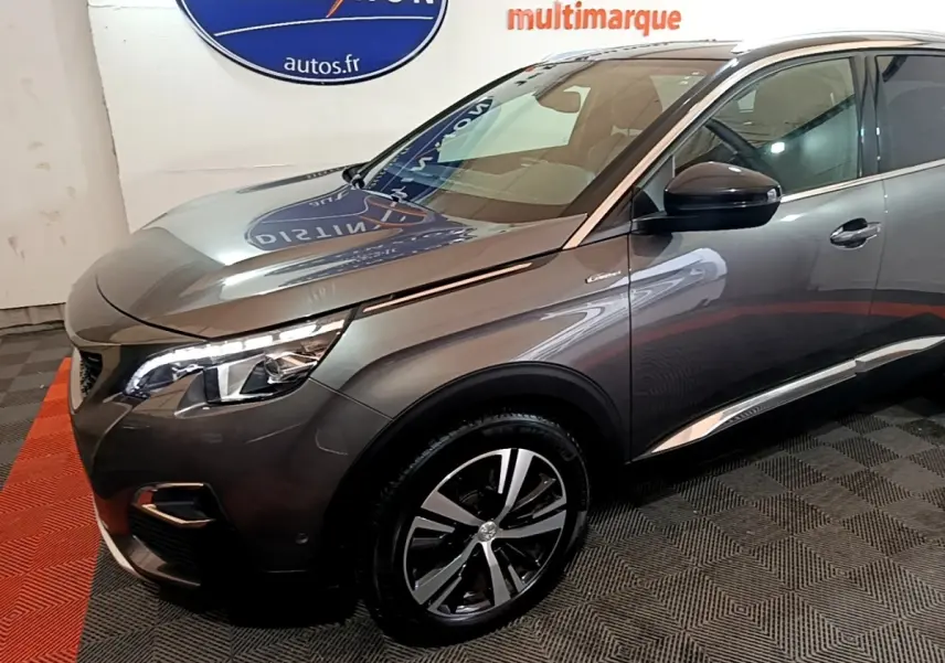 Vue 3/4 avant droit d’un Peugeot 3008 gris foncé avec phares LED et jantes alliage distinctives.