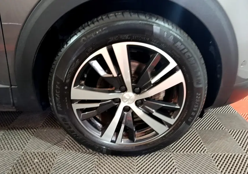 Gros plan sur la roue avant droite avec jante alliage bicolore du Peugeot 3008 gris foncé GT LINE 2020.