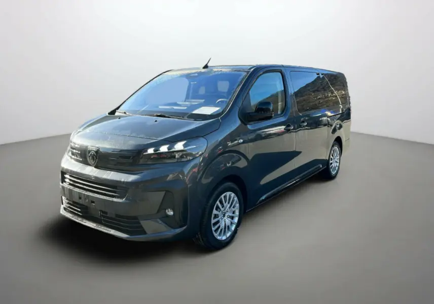 Peugeot Traveller gris titane en 3/4 avant droit, avec jantes tôle et vitres surteintées.
