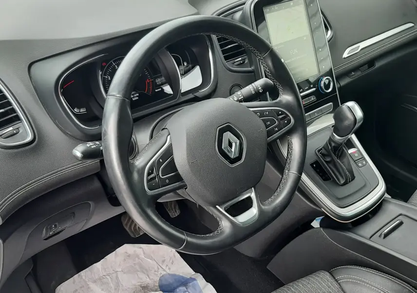 Vue intérieure du poste de conduite du Renault Scénic IV 1.3 TCE 140 Intens, volant cuir noir et console centrale avec écran tactile.