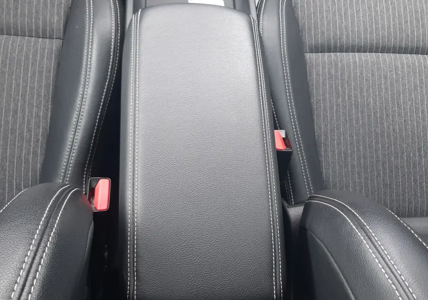 Vue plongeante sur l'accoudoir central en cuir noir avec surpiqûres blanches du Renault Scénic IV 1.3 TCE 140 Intens EDC.