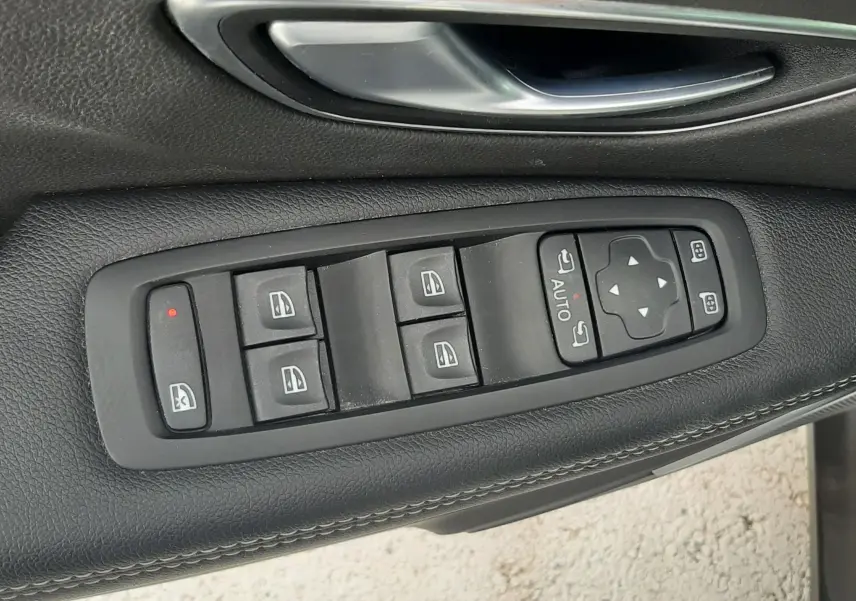 Gros plan sur les commandes de lève-vitres et rétroviseurs côté conducteur d'une Renault Scenic IV 1.3 TCE 140 Intens.