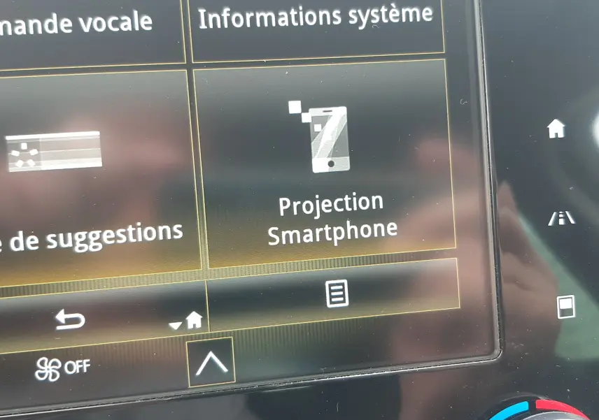 Gros plan sur l'écran tactile central du Renault Scénic IV blanc nacré, affichant l'option "Projection Smartphone".