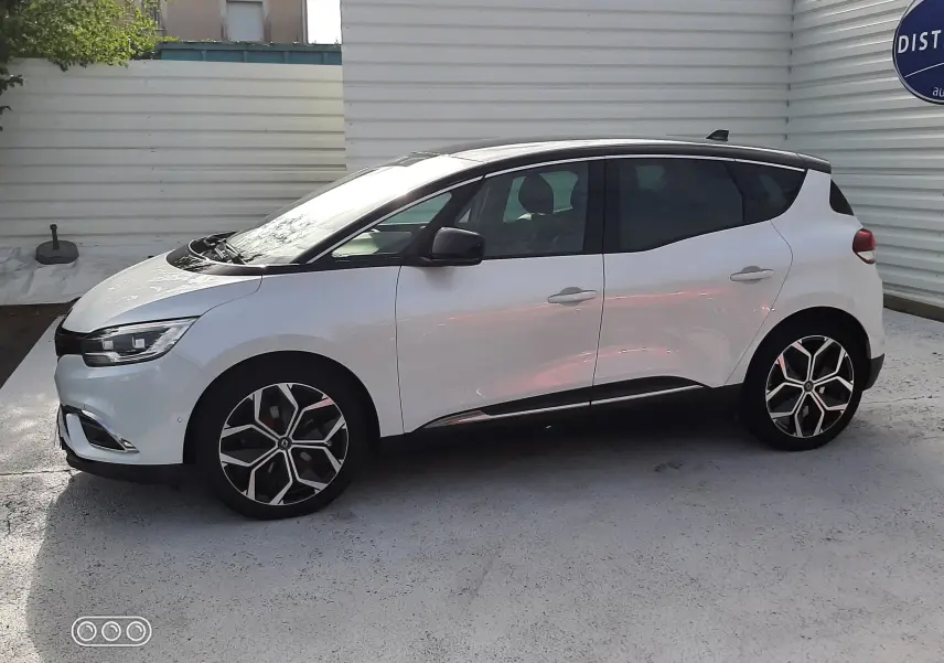 Renault Scénic IV blanc nacré avec toit noir, vue de profil côté gauche, jantes alliage et vitres teintées.