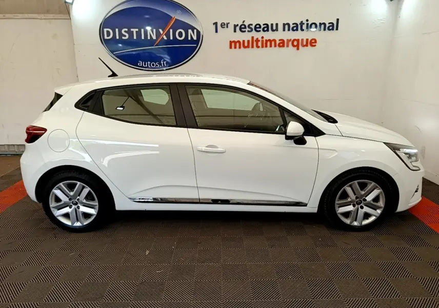 Vue de profil droit d'une Renault Clio Business Blue dCi 85 blanche, avec jantes alliage et feux LED visibles.