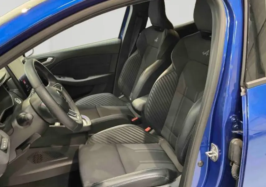 Vue intérieure côté conducteur de la Renault Clio Esprit Alpine E-Tech 2024 avec sièges sport noirs et volant cuir.