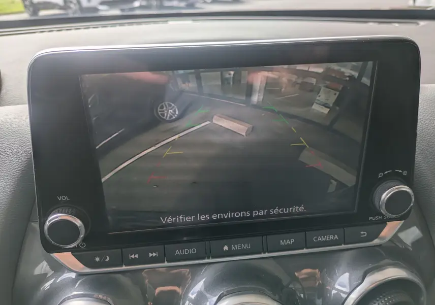 Écran de caméra de recul dans un Nissan Juke rouge 2020, vue intérieure du tableau de bord avec commandes visibles.