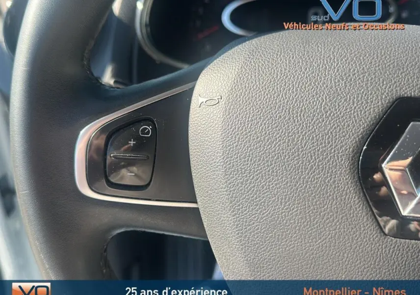 Gros plan sur le volant cuir de la Renault Clio IV Estate Business blanc, montrant les commandes au volant côté gauche.