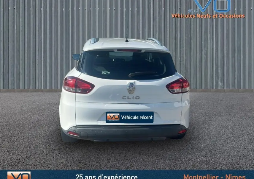 Vue arrière d'une Renault Clio IV Estate Business blanche de 2019 avec vitres surteintées et feux arrière visibles.