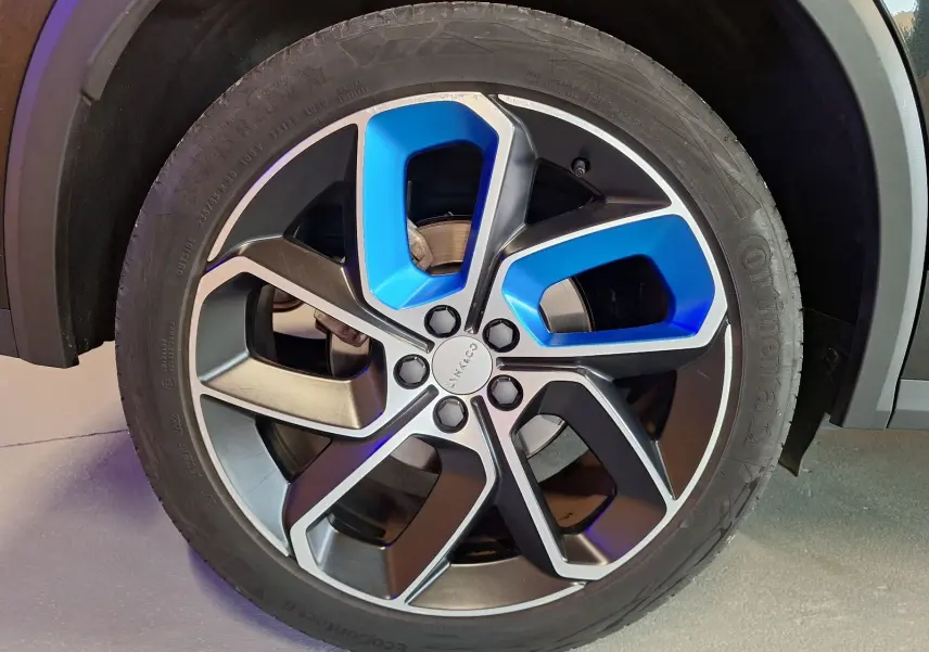 Gros plan sur la jante alliage 20 pouces bicolore noir et bleu du LYNK & CO 01 PHEV 2022 noir.