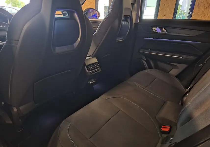 Vue intérieure arrière côté droit du Lynk & Co 01 PHEV 2022 avec sièges noirs et éclairage d'ambiance violet.