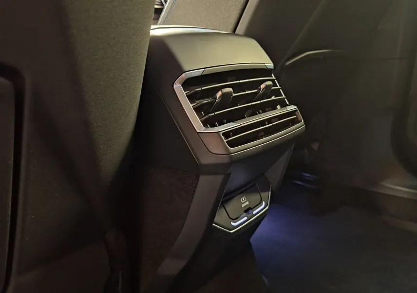 Gros plan sur la console arrière noire du Lynk & Co 01 PHEV 261 DCTH7 avec aérateurs et chargeur USB intégré.