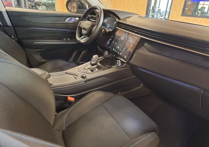 Vue intérieure côté conducteur du Lynk & Co 01 PHEV 2022 noir, avec tableau de bord et écran tactile central.