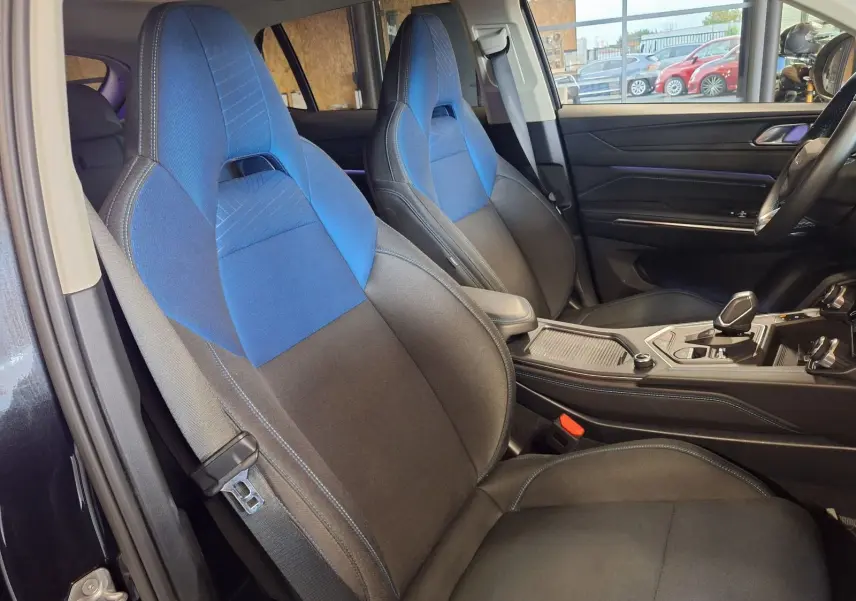 Vue intérieure côté conducteur du Lynk & Co 01 PHEV 2022 avec sièges sport bicolores bleu et noir.