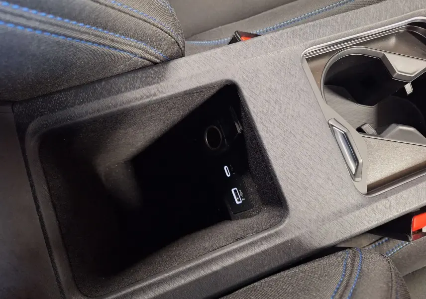 Gros plan sur la console centrale noire du Lynk & Co 01 PHEV 2022 avec ports USB et porte-gobelets.