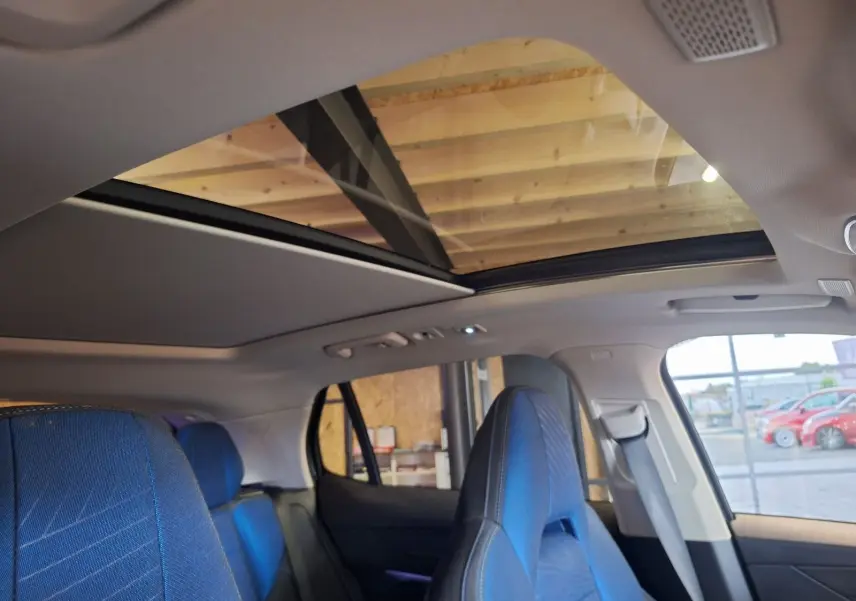 Vue intérieure du toit panoramique électrique et des sièges avant bleus du LYNK & CO 01 noir PHEV 2022.