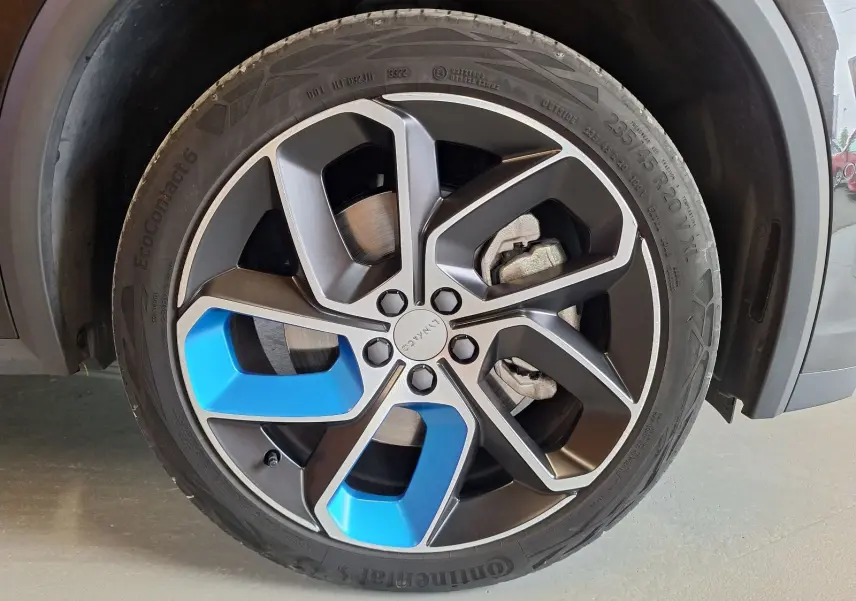 Gros plan sur la jante avant droite noire et bleue du LYNK & CO 01 PHEV 2022 avec pneu Continental.