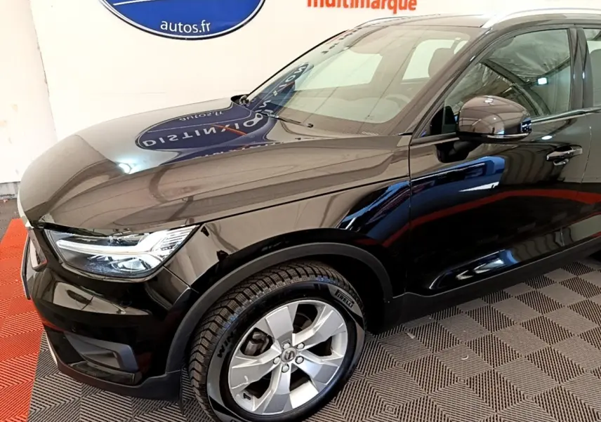 Vue 3/4 avant gauche du Volvo XC40 T2 noir, avec jantes alliage et phares LED distinctifs.