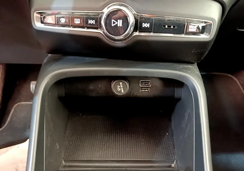 Vue rapprochée de la console centrale noire du Volvo XC40 T2 2020, avec prises USB et bouton 12V visibles.
