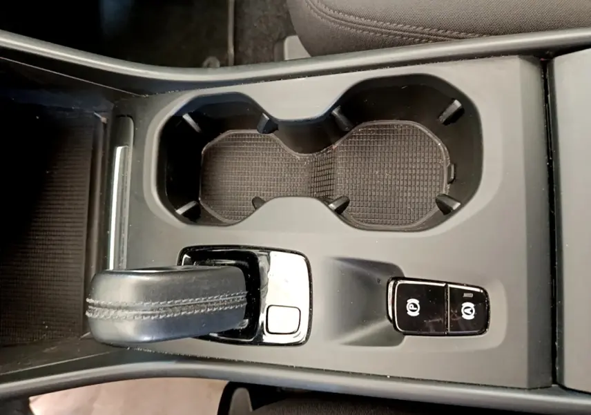 Vue rapprochée de la console centrale noire du Volvo XC40 T2 2020 avec levier de vitesse automatique et boutons de frein à main électrique.