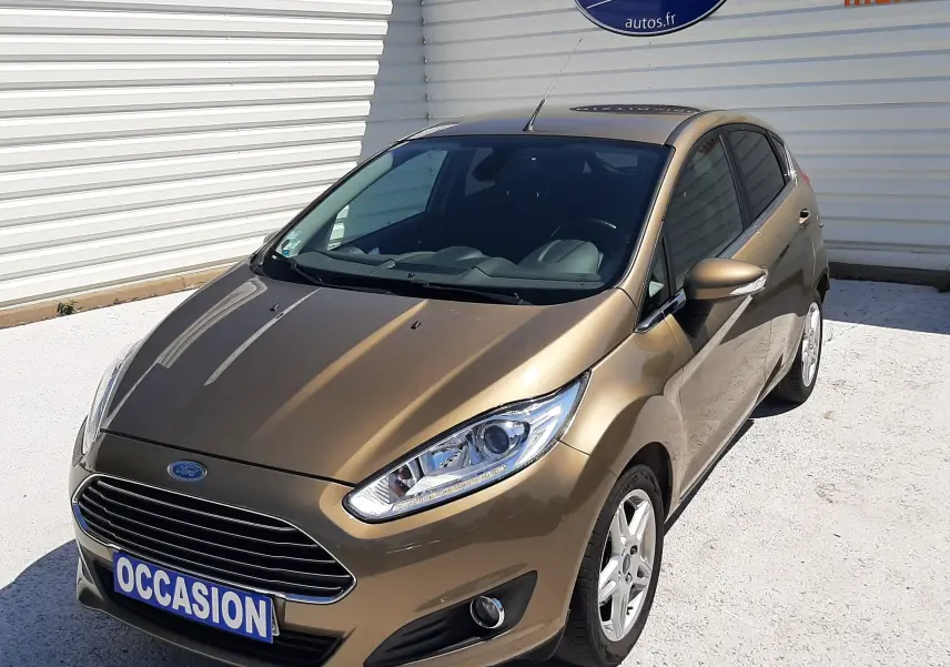 Ford Fiesta 1.0 EcoBoost Titanium marron métal vue 3/4 avant droit avec plaque occasion visible.