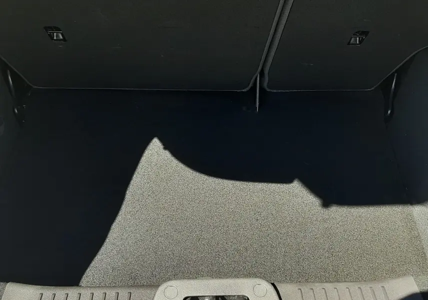 Coffre ouvert vu de face d'une Ford Fiesta marron métal, montrant un espace de chargement propre et vide.