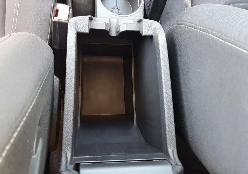 Vue plongeante sur le rangement central noir entre les sièges avant d'une Ford Fiesta 2013, finition Titanium.