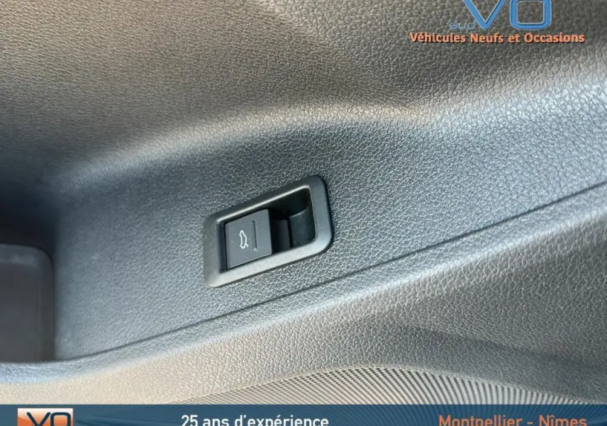 Gros plan sur le bouton d'ouverture du coffre dans l'habitacle d'un Audi Q3 Sportback noir 2020 S line