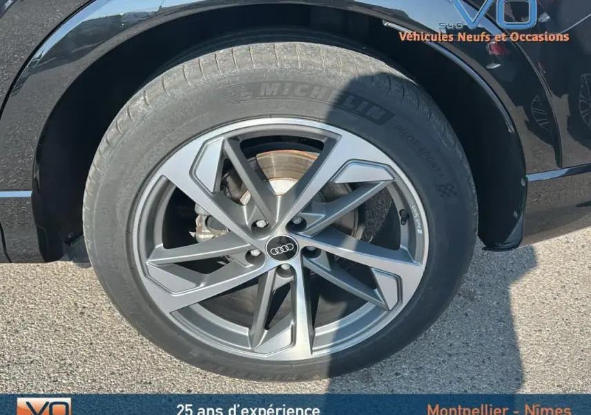 Gros plan sur la roue avant droite de l'Audi Q3 Sportback noir, mettant en valeur la jante S line et le pneu Michelin.