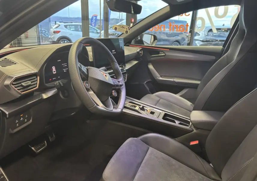 Intérieur avant droit de la CUPRA Leon gris Magnetic, sièges baquets suédine noire avec surpiqûres cuivrées et volant cuir.