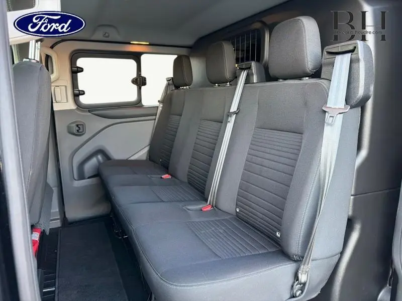 Vue intérieure côté droit de la banquette arrière 3 places en tissu gris du Ford Transit Custom Fourgon noir Agate 2023.