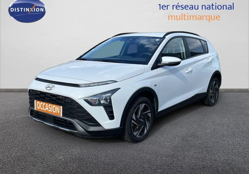 Vue 3/4 avant droit d'un Hyundai Bayon blanc polaire avec toit noir et jantes alliage sombres.