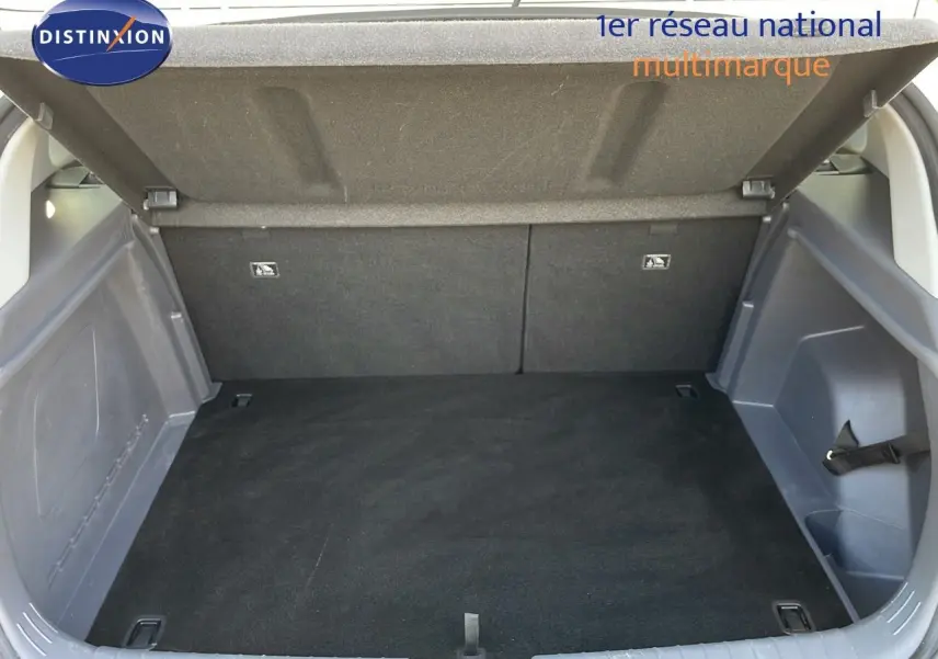 Coffre ouvert d’une Hyundai Bayon blanc polaire, vue arrière montrant l’espace de chargement vide et les finitions intérieures grises.