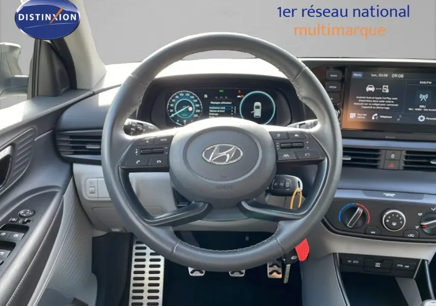 Vue intérieure centrée sur le volant cuir et le tableau de bord numérique du Hyundai Bayon blanc polaire 2022.