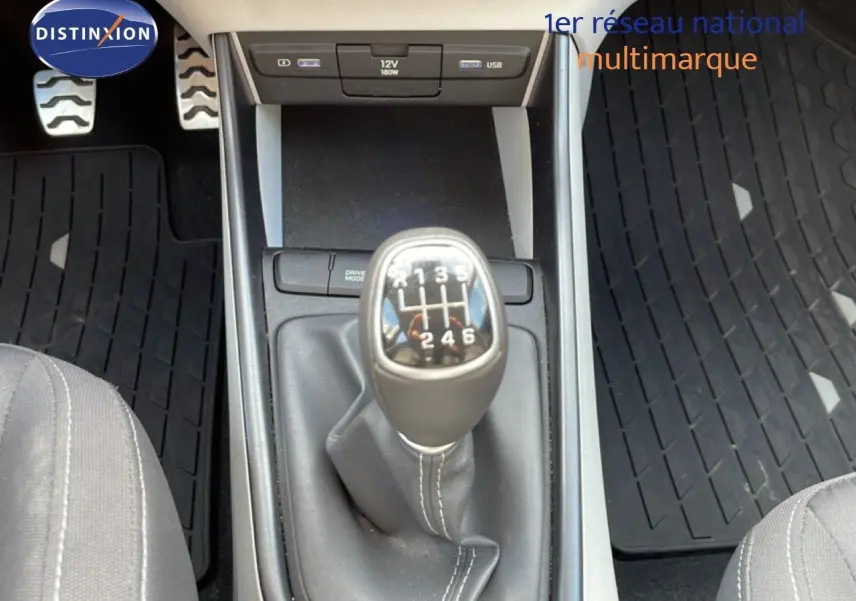 Le levier de vitesses manuel en gros plan au centre de la console d'une Hyundai Bayon blanche, intérieur tissu gris.