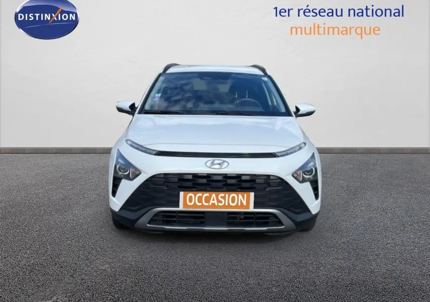 Vue frontale d'un Hyundai Bayon blanc polaire avec calandre noire et plaque "OCCASION" visible.