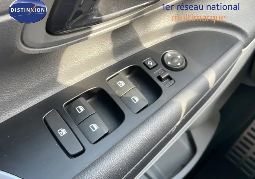 Gros plan sur les commandes des vitres et rétroviseurs côté conducteur de la Hyundai Bayon 2022 en intérieur noir.