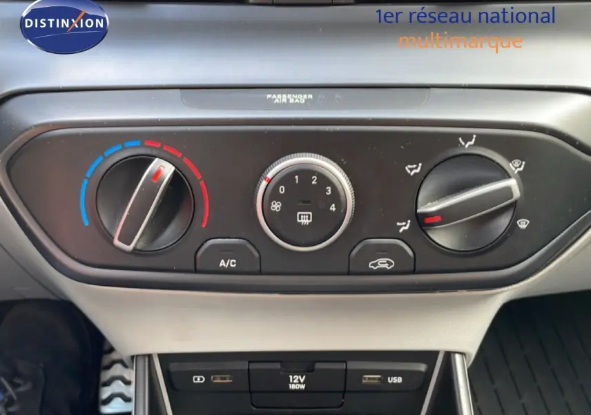 Vue rapprochée des commandes de climatisation et des ports USB d’une Hyundai Bayon blanche polaire, version hybride 2022.
