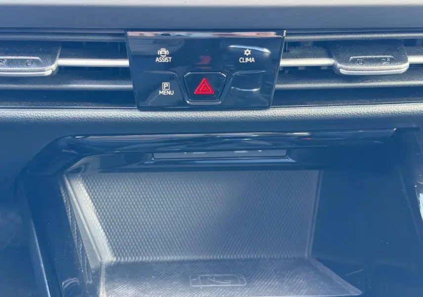 Détail de la console centrale d’une Volkswagen Golf 2024 gris lunaire, avec boutons d’assistance et climatisation.