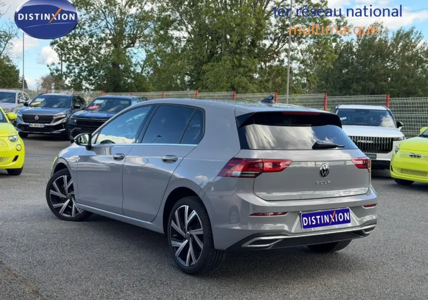 Volkswagen Golf 1.5 TSI gris lunaire vue 3/4 arrière droit, jantes alliage et feux arrière LED visibles.