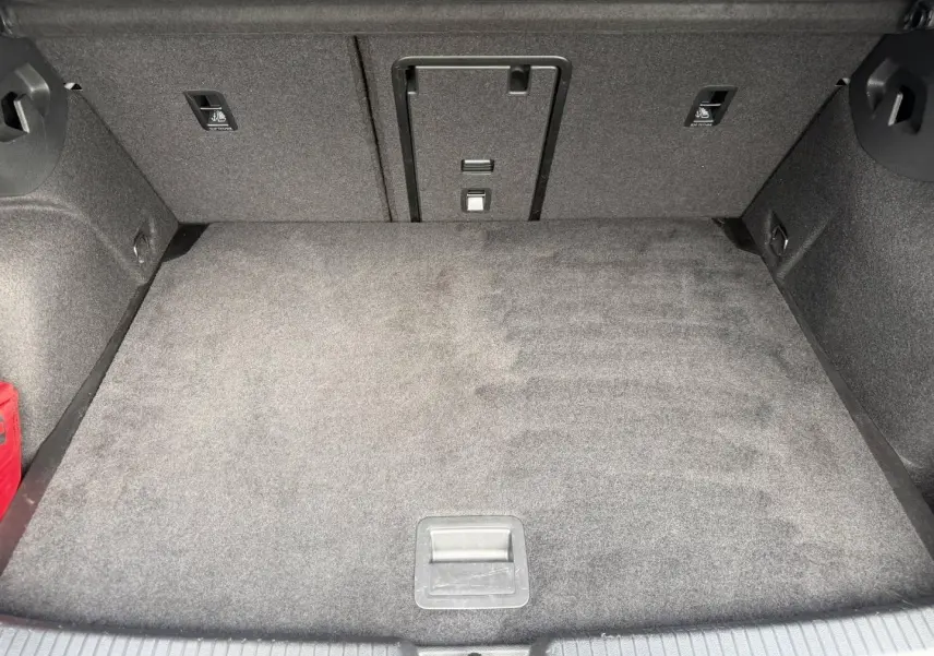 Coffre spacieux de Volkswagen Golf 1.5 TSI 2024, vue intérieure montrant le tapis gris et la trappe à skis centrale.